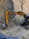 Excavator Loader with rised backhoe standing in sand Royalty Free Stock Photo