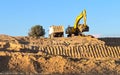 Excavator loader with rised backhoe and a truck in a sky background Royalty Free Stock Photo