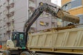 Excavator loading dirt in dumpster truck Royalty Free Stock Photo