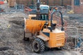 Excavator loading dumper during groundworks on new residential housing construction site