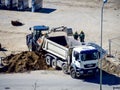 Excavator loading dumper truck. Excavator loading dumper truck tipper in sand pit over blue sky Royalty Free Stock Photo