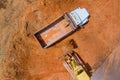 An excavator is loading earth into a dump truck, which is heavy construction equipment on construction site Royalty Free Stock Photo