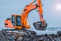 Excavator is loading excavation to the truck. Excavators hydraulic are heavy construction equipment consisting of a boom, dipper