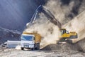 Excavator is loading excavation to the truck. Excavators hydraulic are heavy construction equipment consisting of a boom, dipper
