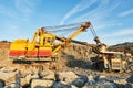 Excavator loading granite or ore into dump truck at opencast Royalty Free Stock Photo