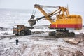 Excavator loading granite or ore into dump truck at opencast Royalty Free Stock Photo