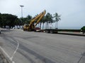 Excavator loading onto flatbed truck