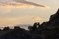 Excavator loading soil into a dump truck at dusk during road construction, creating a dramatic silhouette against the evening sky Royalty Free Stock Photo