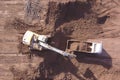 Excavator loading soil to a dump truck on a new development site. Royalty Free Stock Photo