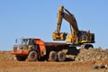 Mining Excavator loading truck in mine quarry Royalty Free Stock Photo