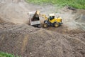 excavator loads crushed stone into dump truck