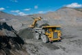 Excavator loads ore into a dump truck.