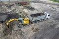 Excavator loads sand into a truck