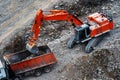 The excavator loads stone debris into the car body. Clearing the territory for the construction of houses and roads. View from