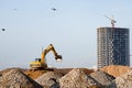 Excavator loads of stone and rubble for processing into cement or concrete for construction work