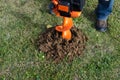 Excavator machine digging hole into grass