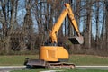 Excavator machine moves with raised bucket on construction site