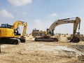Excavator machinery at construction site, desert in background.