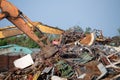 Excavator magnet lifting steel scraps from recycling materials pile at scrap yard in recycling factory. Excavator with electro and Royalty Free Stock Photo