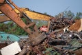 Excavator magnet lifting steel scraps from recycling materials pile at scrap yard in recycling factory. Excavator with electro and Royalty Free Stock Photo