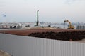 An excavator makes a mound of sand on the seashore. Protection of the beach area for the winter from flooding