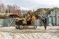 Excavator-mounted hydraulic jackhammer in a marble quarry