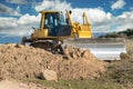 Excavator moving dirt and sand at a construction site