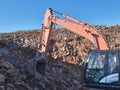 Excavator is moving a rock boulders during road construction on the rocky soils Royalty Free Stock Photo