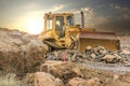 Excavator moving rocks on a road construction site