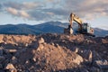 Excavator moving stone and earth