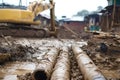 Excavator working on laying pipes in muddy construction site Royalty Free Stock Photo