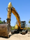 Excavator parked in the sand ready for maintenance work on the beach Royalty Free Stock Photo
