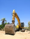 Excavator parked in the sand ready for maintenance work on the beach Royalty Free Stock Photo