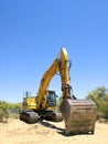 Excavator parked in the sand ready for maintenance work on the beach Royalty Free Stock Photo