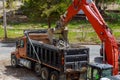 Excavator picks up construction waste for loading onto a truck