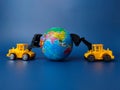 Excavator pushing earth globe on blue background