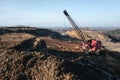 Excavator in the red clay quarry