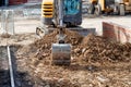 Excavator reducing ground level as part of groundworks and parking space construction on new housing construction site