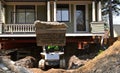 An excavating machine removing earth from under a house Royalty Free Stock Photo