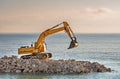 Excavator shifts stones on the beach. Royalty Free Stock Photo