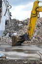 Excavator with shovel demolishing a huge building Royalty Free Stock Photo