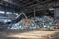 Excavator stacks trash in big pile at sorting modern waste recycling processing plant. Separate and sorting garbage collection.