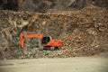 Excavator amid stones and rocks in a quarry
