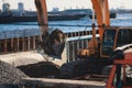 Excavator unloading sand into the dump truck on the construction site, excavating and working during road works, backhoe and Royalty Free Stock Photo