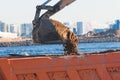 Excavator unloading sand into the dump truck on the construction site, excavating and working during road works, backhoe and Royalty Free Stock Photo