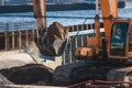 Excavator unloading sand into the dump truck on the construction site, excavating and working during road works, backhoe and Royalty Free Stock Photo