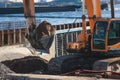 Excavator unloading sand into the dump truck on the construction site, excavating and working during road works, backhoe and Royalty Free Stock Photo