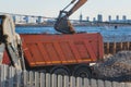 Excavator unloading sand into the dump truck on the construction site, excavating and working during road works, backhoe and Royalty Free Stock Photo