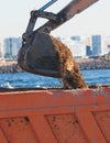 Excavator unloading sand into the dump truck on the construction site, excavating and working during road works, backhoe and Royalty Free Stock Photo