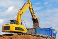 Excavator unloading sand into tipper truck Royalty Free Stock Photo